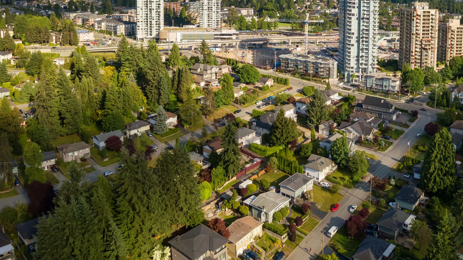 Aerial view of established Port Moody homes with towers rising in the distance
